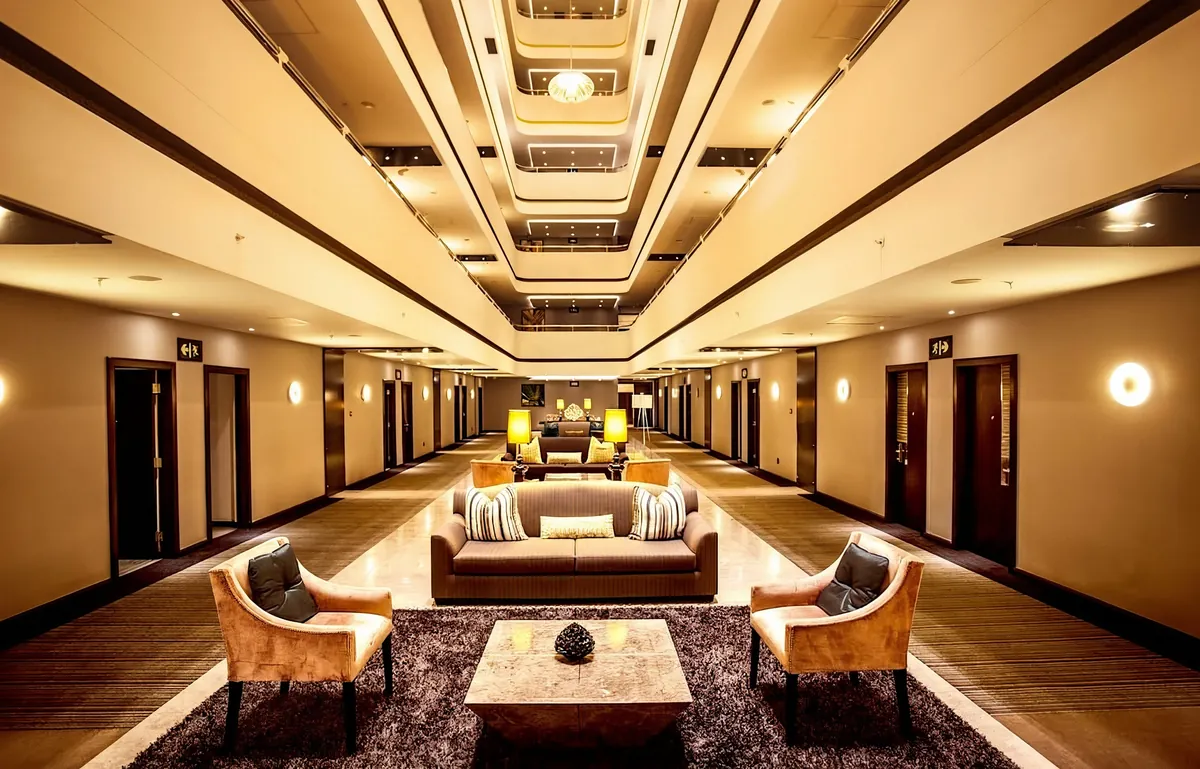 Hotel lobby lounge with symmetrical seating beneath a tiered ceiling