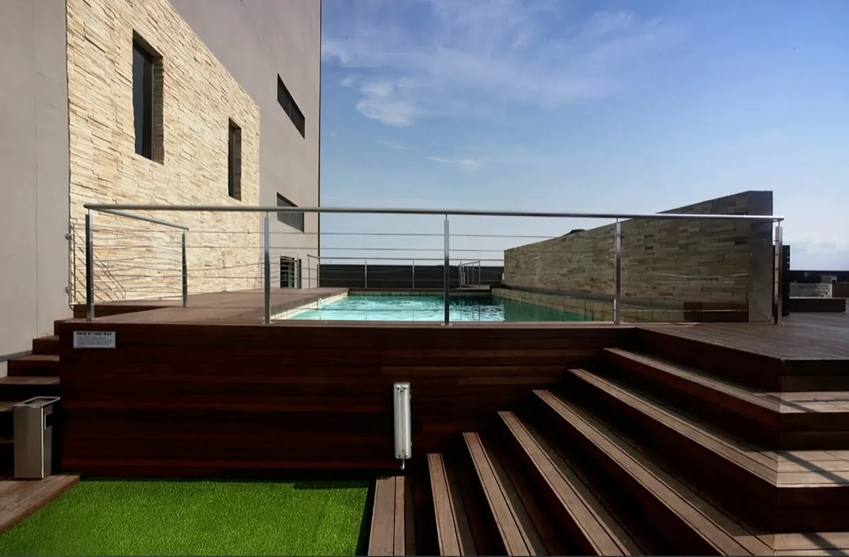 Rooftop swimming pool and timber deck in daylight