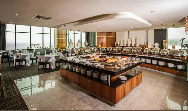 Breakfast buffet with copper chafing dishes beside floor-to-ceiling windows