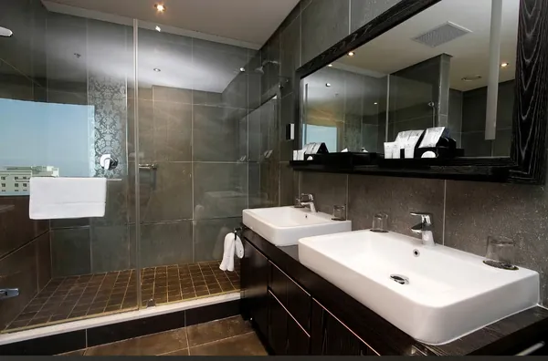 Guest bathroom with twin basins, wide mirror and a glass walk-in shower