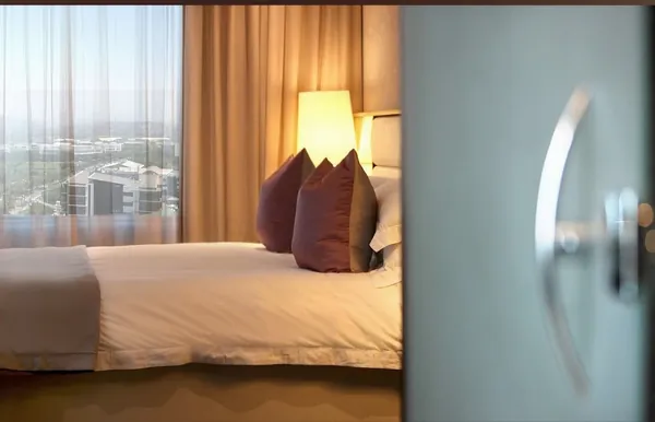 Guest room seen through the doorway, with city views from the window