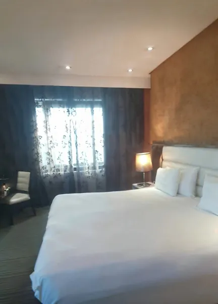 Standard king room with a padded white headboard and bronze feature wall
